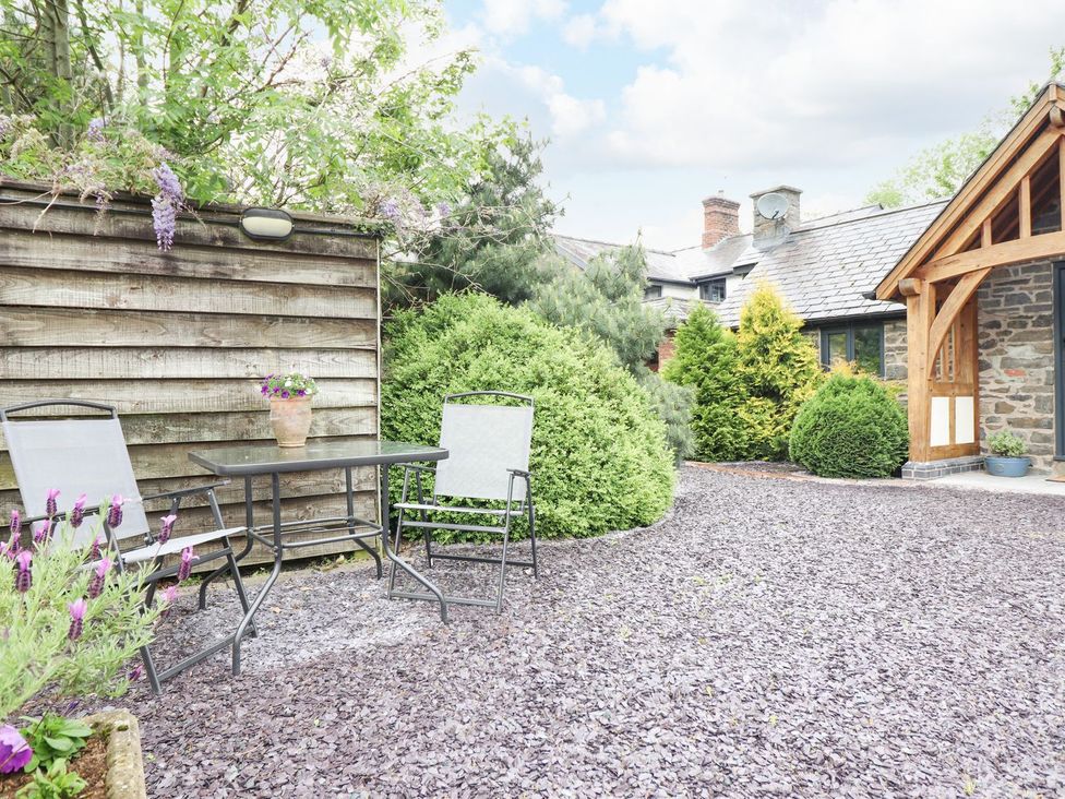 An outdoor space with a table and chairs at The Talkhouse Cottage in Caersws