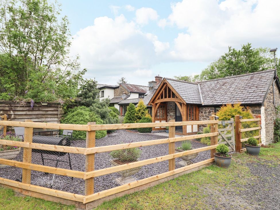 A cottage with a fenced area and gravel at The Talkhouse Cottage in Caersws