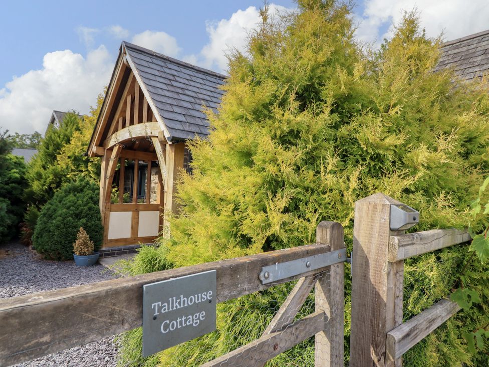 Exterior view of Talkhouse Cottage with greenery at Talkhouse Cottage Caersws