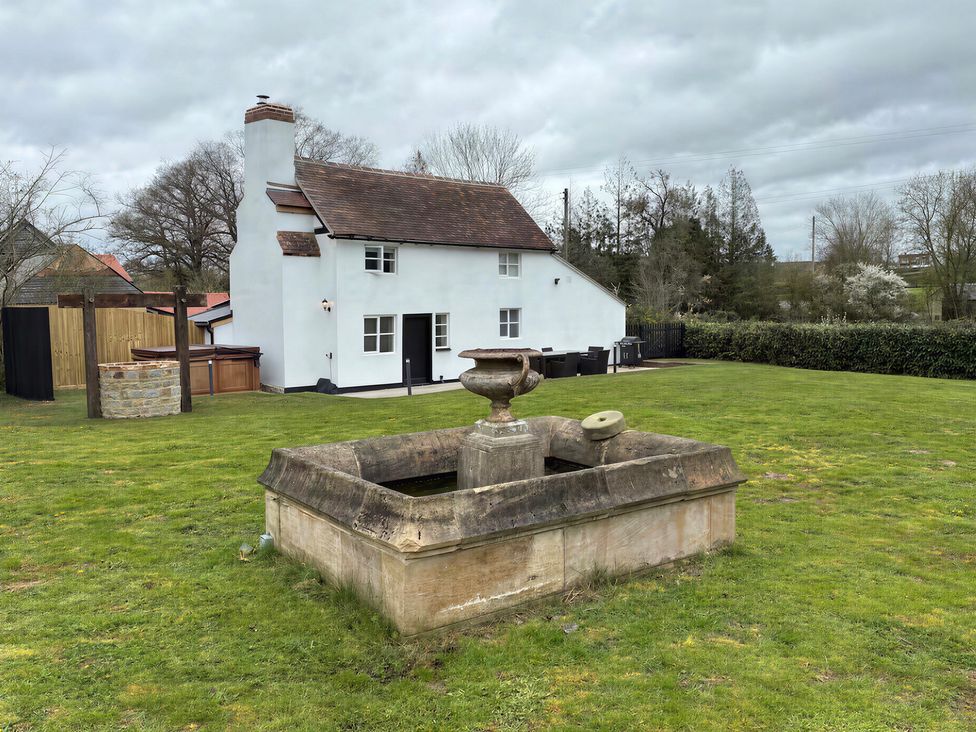 A house with a fountain and lawn at Lake Farm in Gloucester