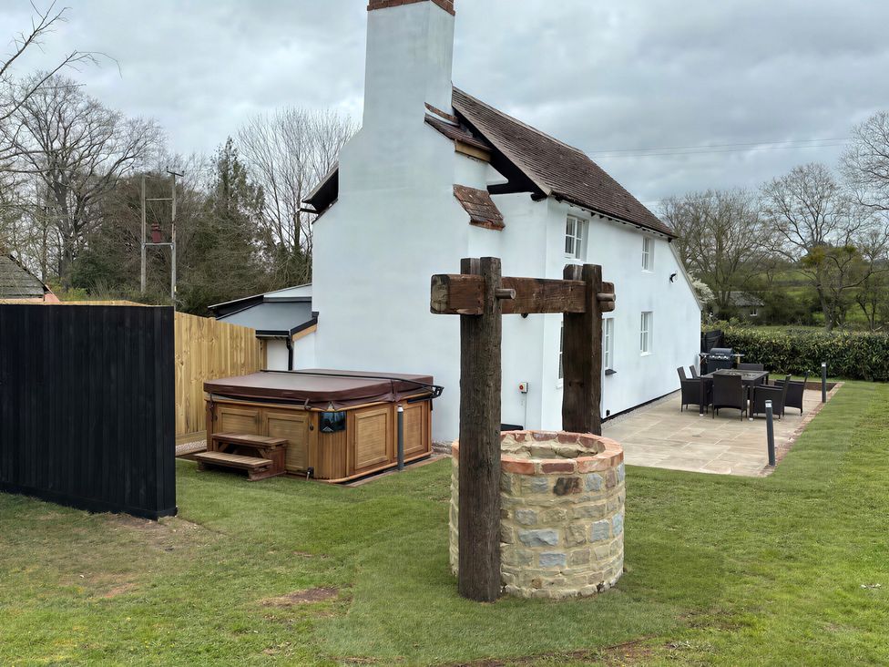 An outdoor area with a hot tub, well, and outdoor furniture at Lake Farm in Gloucester