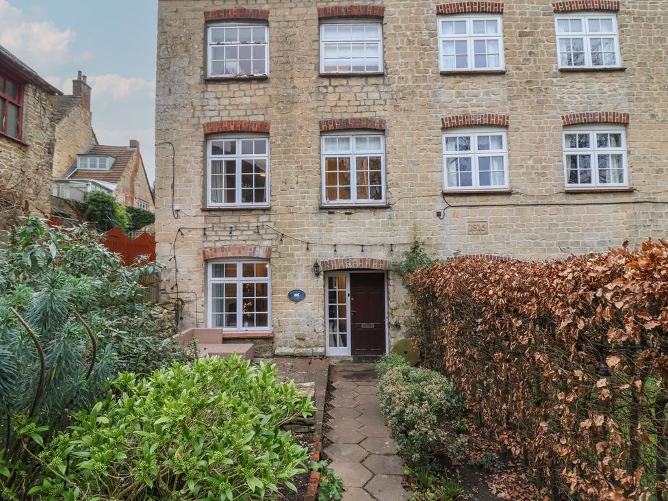 A building with windows and a door at Waterloo Mill Cottage in Wotton-Under-Edge