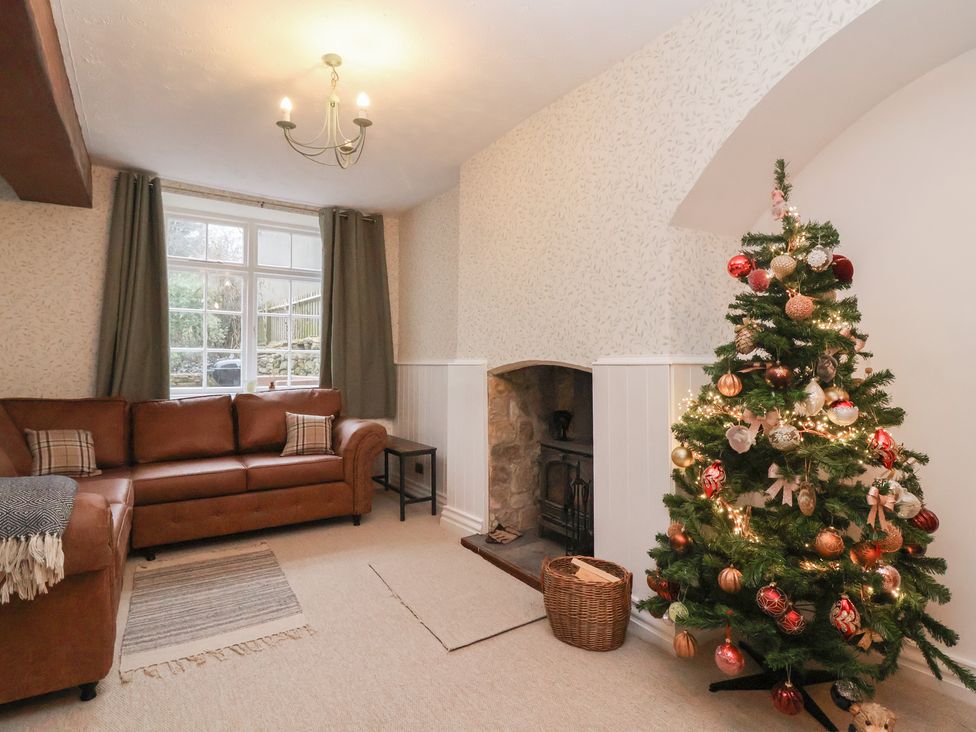 A living room with a sofa and Christmas tree at Waterloo Mill Cottage in Wotton-Under-Edge