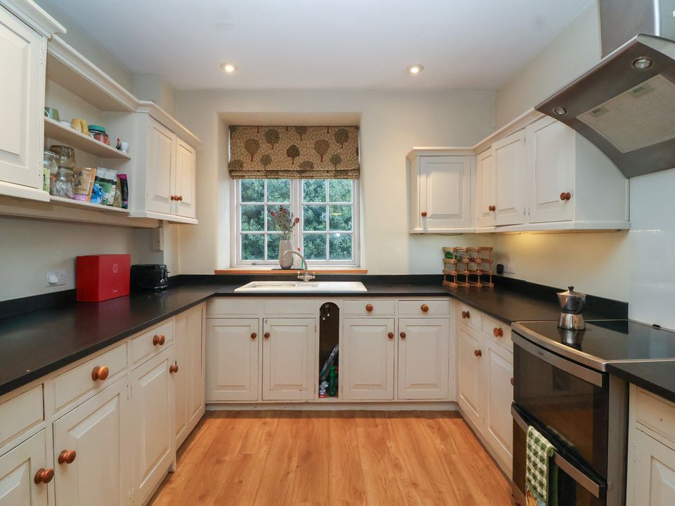 A kitchen with cabinets and countertop at Waterloo Mill Cottage in Wotton-Under-Edge