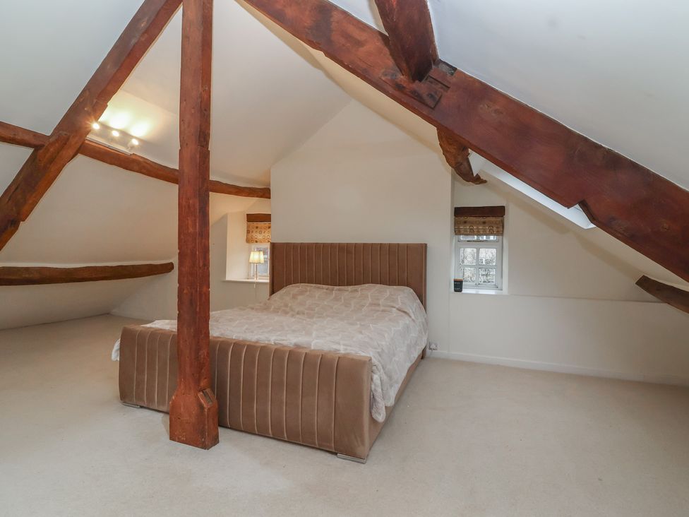 A bedroom with a bed and window at Waterloo Mill Cottage Wotton-Under-Edge