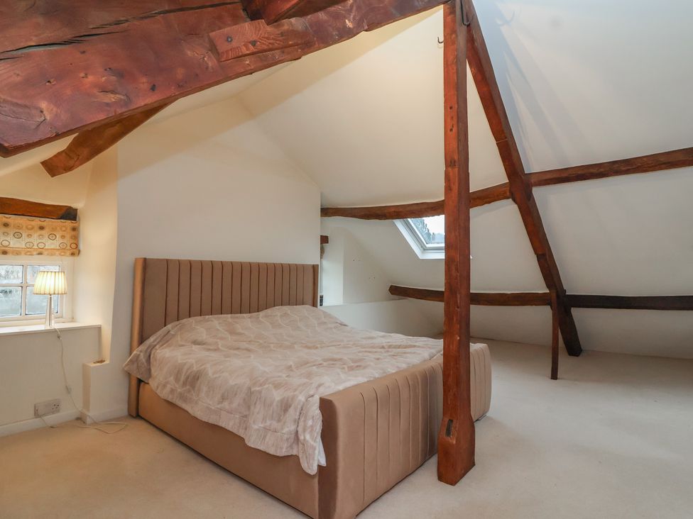 A bedroom with a bed and a lamp at Waterloo Mill Cottage in Wotton-Under-Edge
