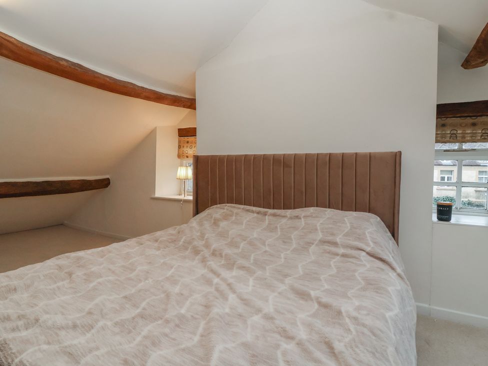 A bedroom with a bed and lamp at Waterloo Mill Cottage in Wotton-Under-Edge