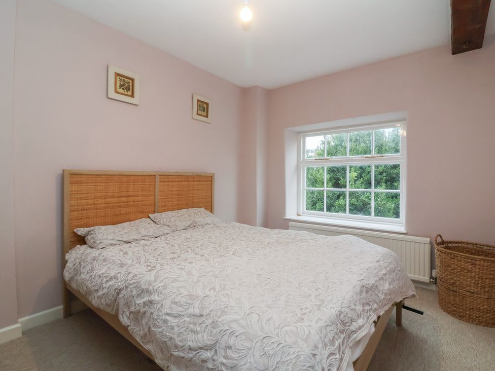 A bedroom with a double bed and window at Waterloo Mill Cottage in Wotton-Under-Edge