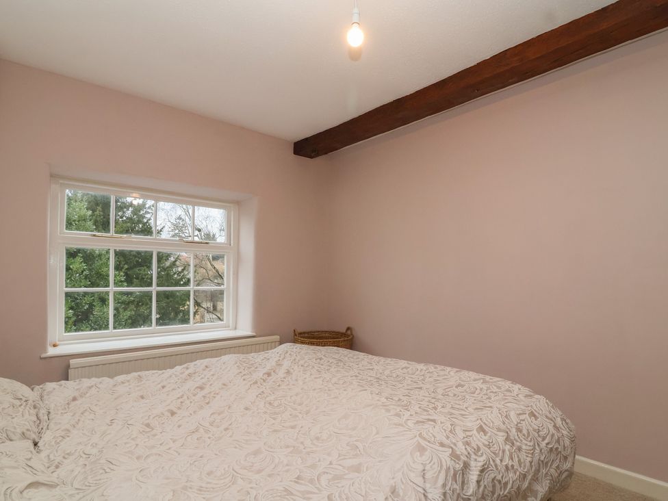 A bedroom with a bed and window at Waterloo Mill Cottage in Wotton-Under-Edge