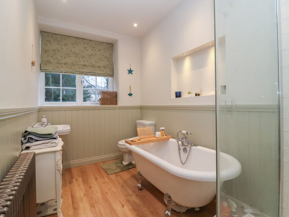 A bathroom with a bathtub, sink, and shower at Waterloo Mill Cottage in Wotton-Under-Edge