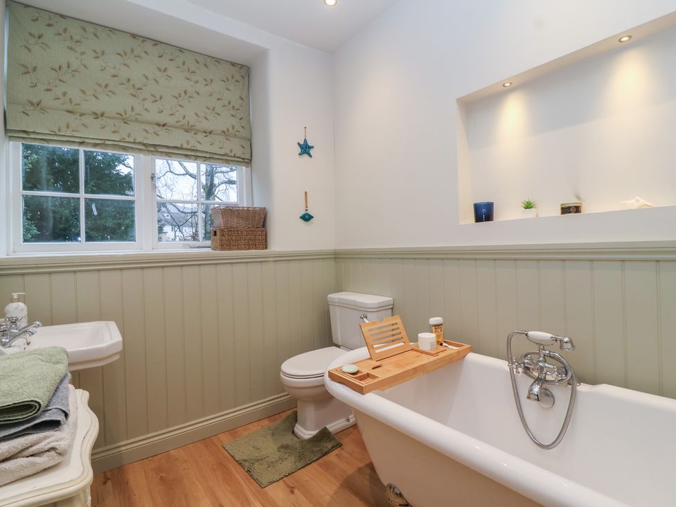 A bathroom with a bathtub, toilet, and sink at Waterloo Mill Cottage Wotton-Under-Edge