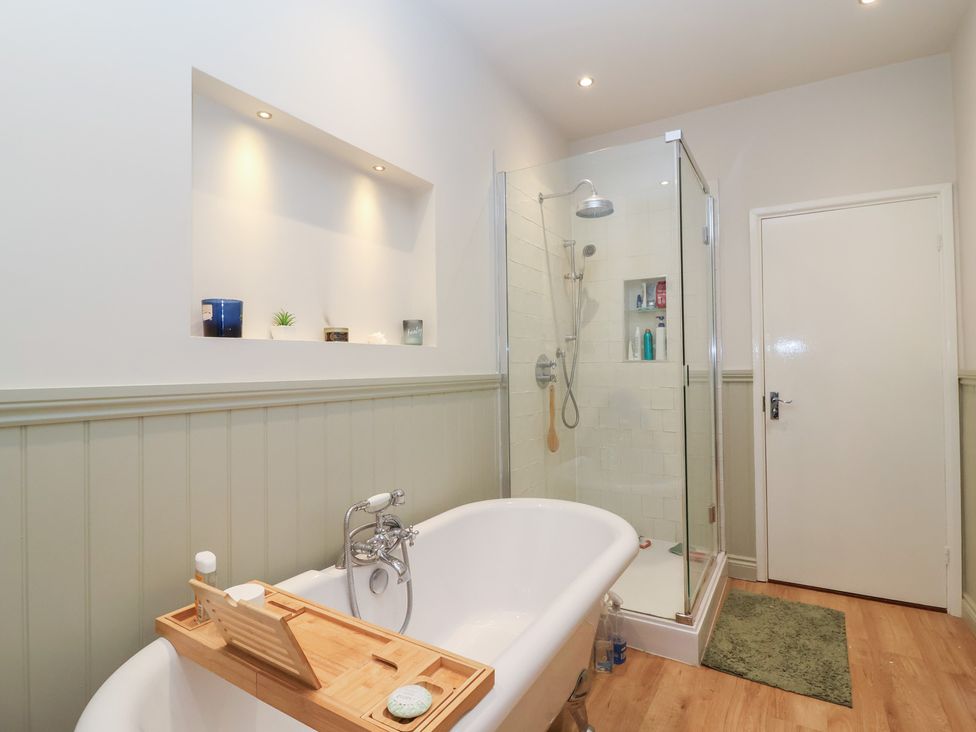 A bathroom with a bathtub and shower at Waterloo Mill Cottage in Wotton-Under-Edge