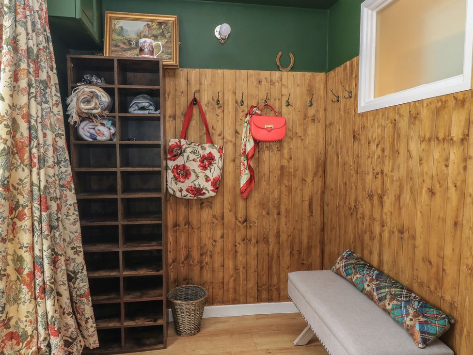 An entryway with storage cubby and hooks at Waterloo Mill Cottage in Wotton-Under-Edge