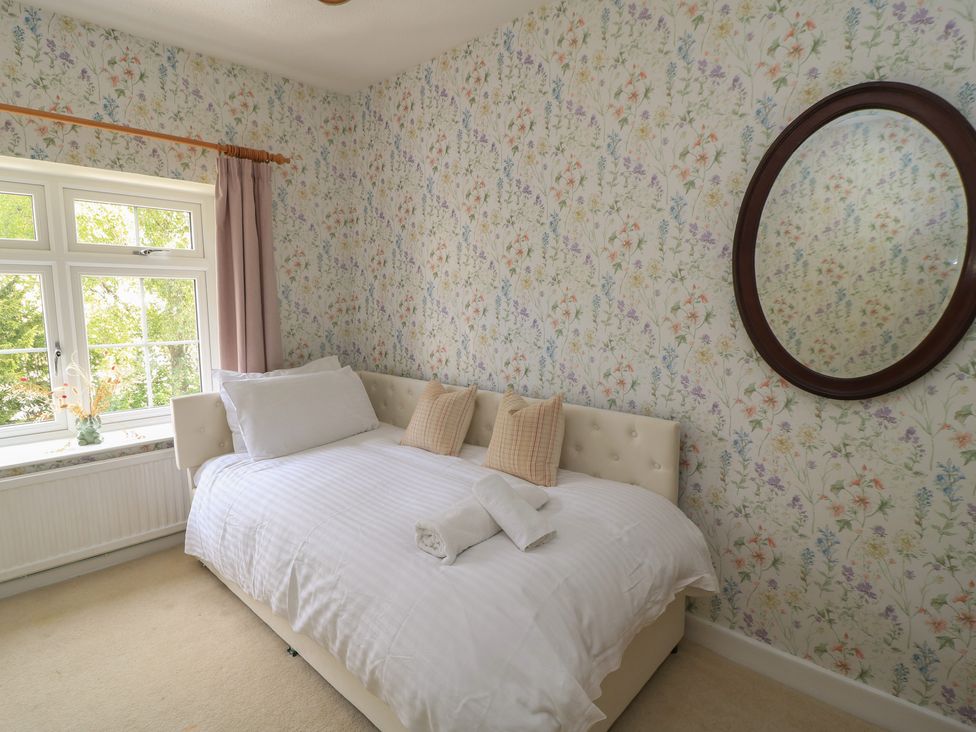 A bedroom with a bed and window at Waterloo Mill Cottage in Wotton-Under-Edge