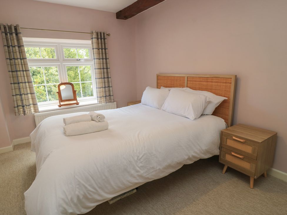 A bedroom with a bed and bedside table at Waterloo Mill Cottage in Wotton-Under-Edge