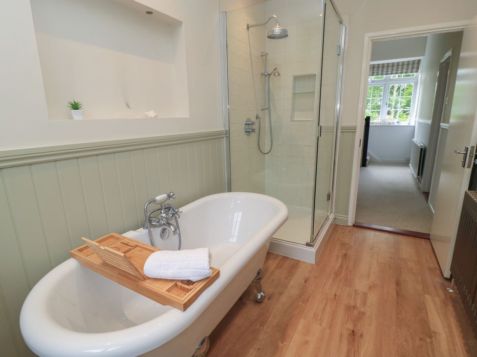A bathroom with a bathtub and shower at Waterloo Mill Cottage Wotton-Under-Edge