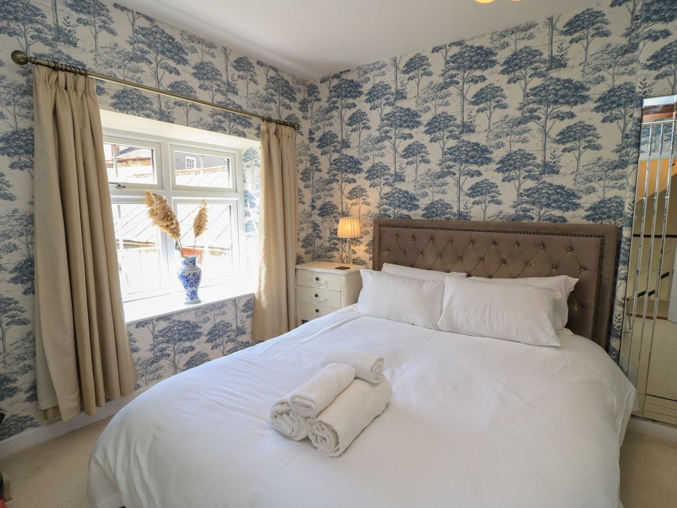 A bedroom with a bed and window at Waterloo Mill Cottage in Wotton-Under-Edge