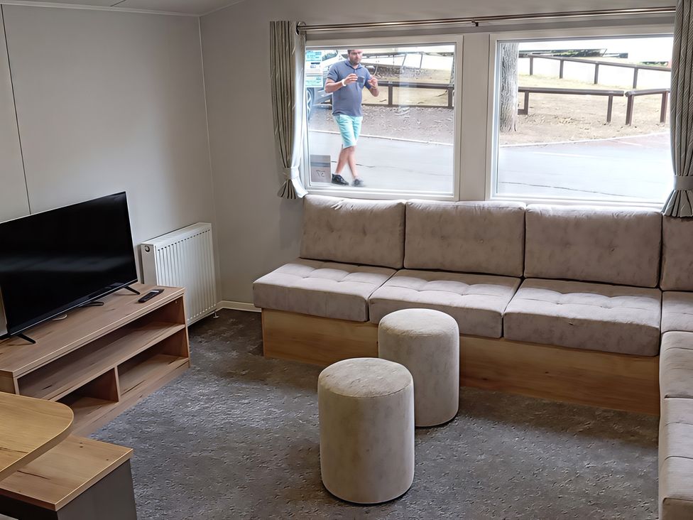 A living room with a sofa and television at Caravan Thorness Bay Holiday Park Thorness Lane