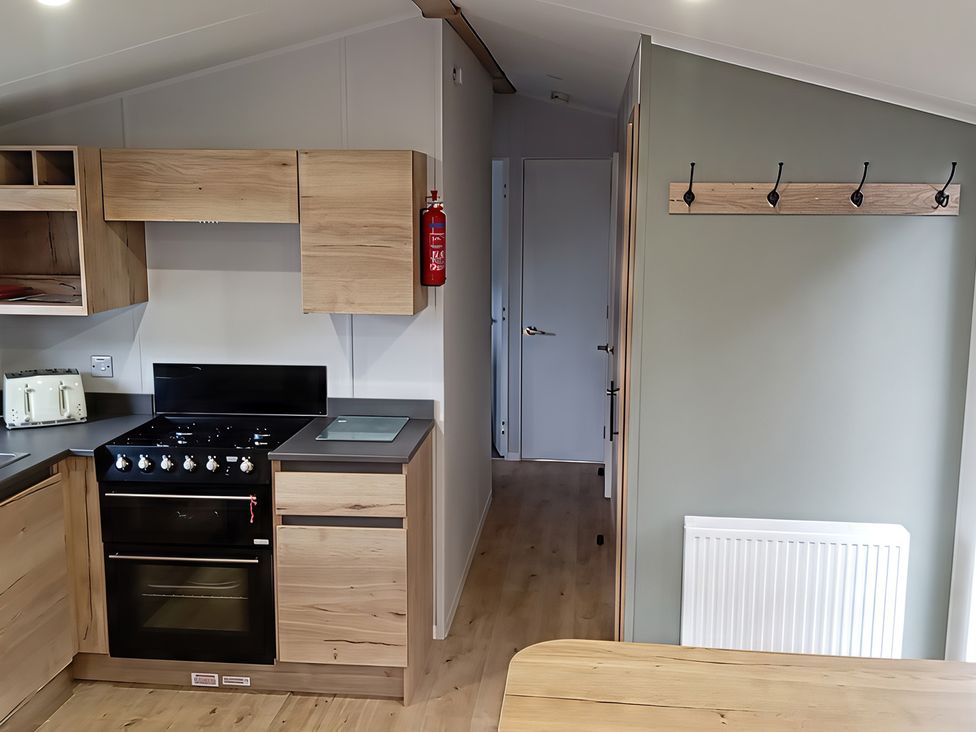 A kitchen with cabinets, stove, and toaster at Caravan Thorness Bay Holiday Park, Thorness Lane