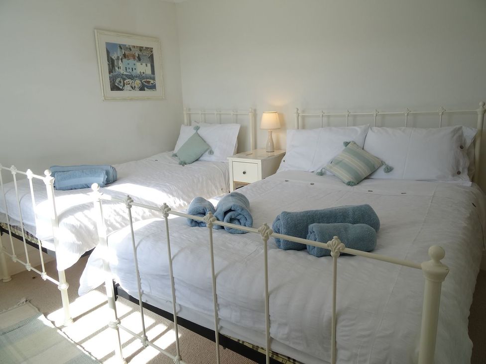A bedroom with two beds and a nightstand at Mount Pleasant in Padstow