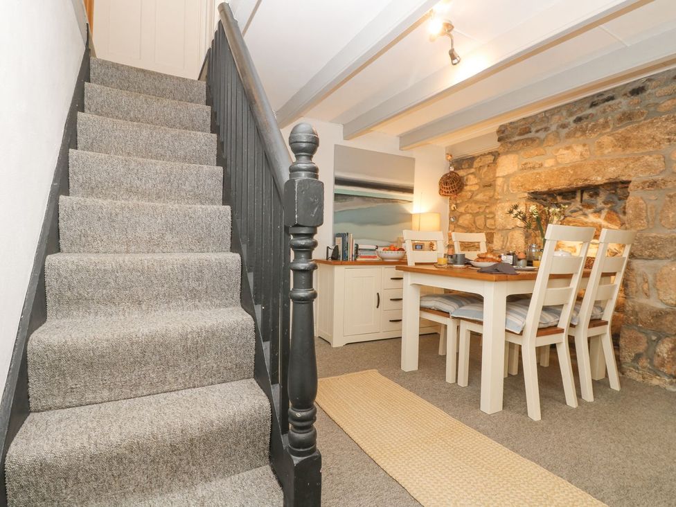 A dining room with a table and chairs at Driftwood Cottage Helston