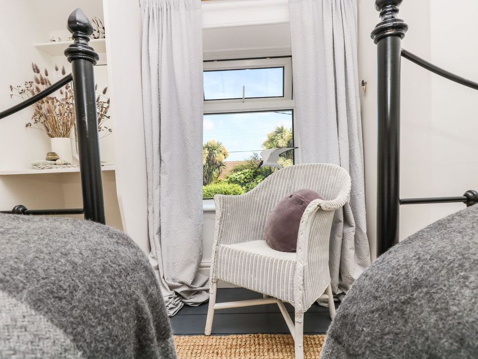 A bedroom featuring a chair and window at Driftwood Cottage Helston