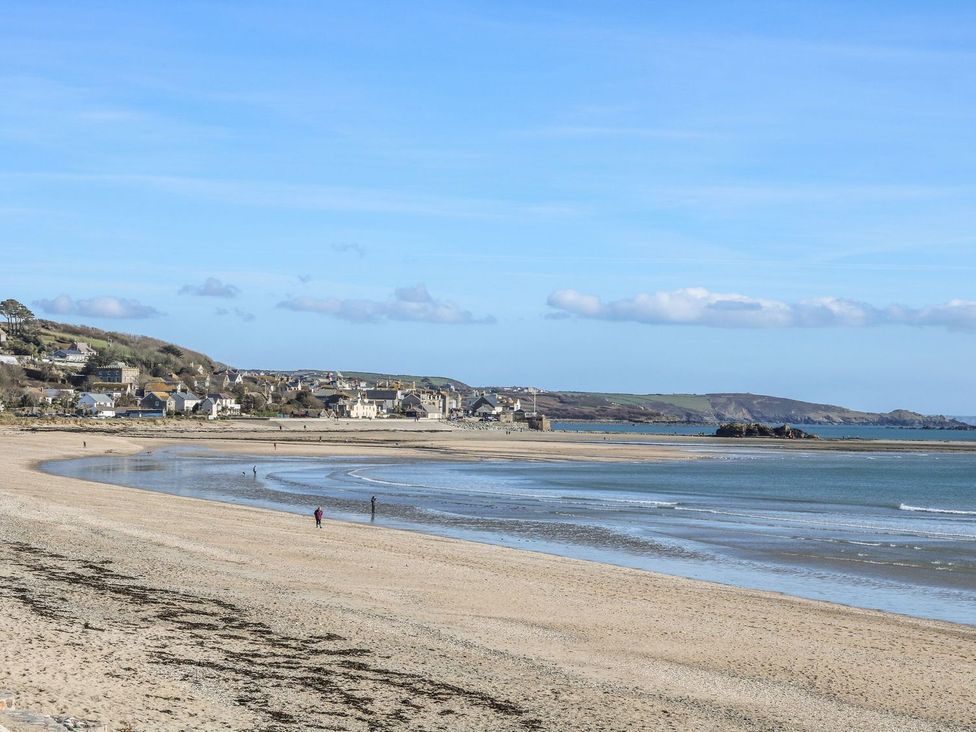 A beach with a view of a town in the background at Driftwood Cottage in Helston
