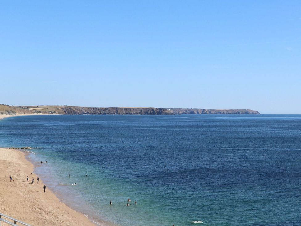 A beach with people swimming at Driftwood Cottage in Helston