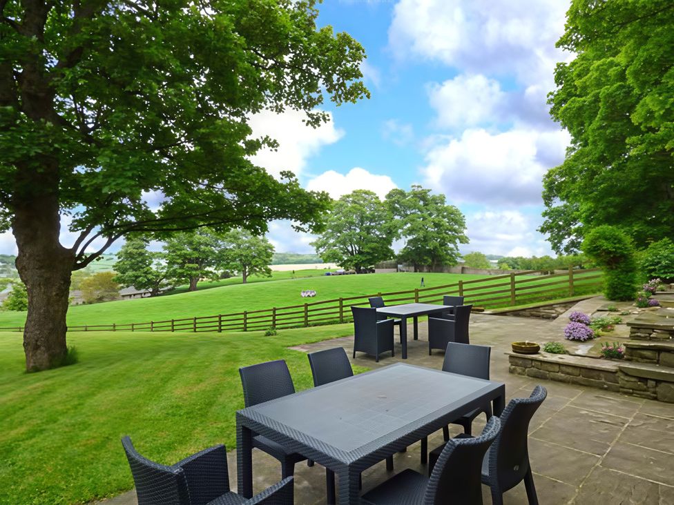 A garden with a dining area and views of green fields at Beningborough