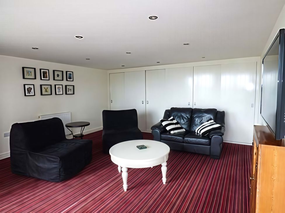 A living room with a sofa and chairs around a coffee table at Beningborough 