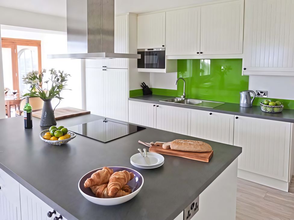 A kitchen with a stove, sink, and kitchen island at Beningborough