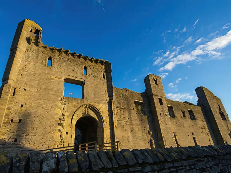 A castle with stone walls and an archway under a blue sky at Beningborough