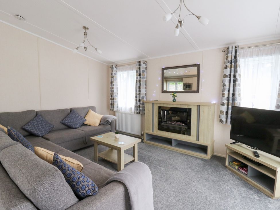 A living room with a sofa and television at Beechwood Lodge