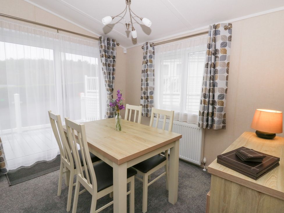 A dining room with a table and chairs at Beechwood Lodge