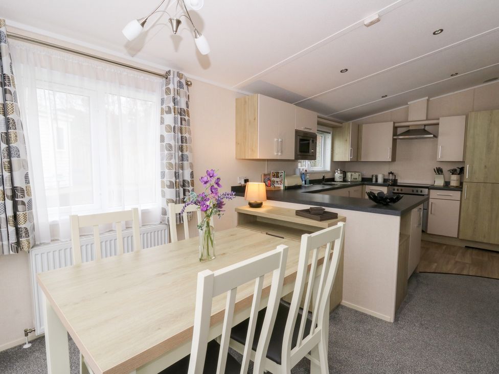 A kitchen with a table and chairs at Beechwood Lodge