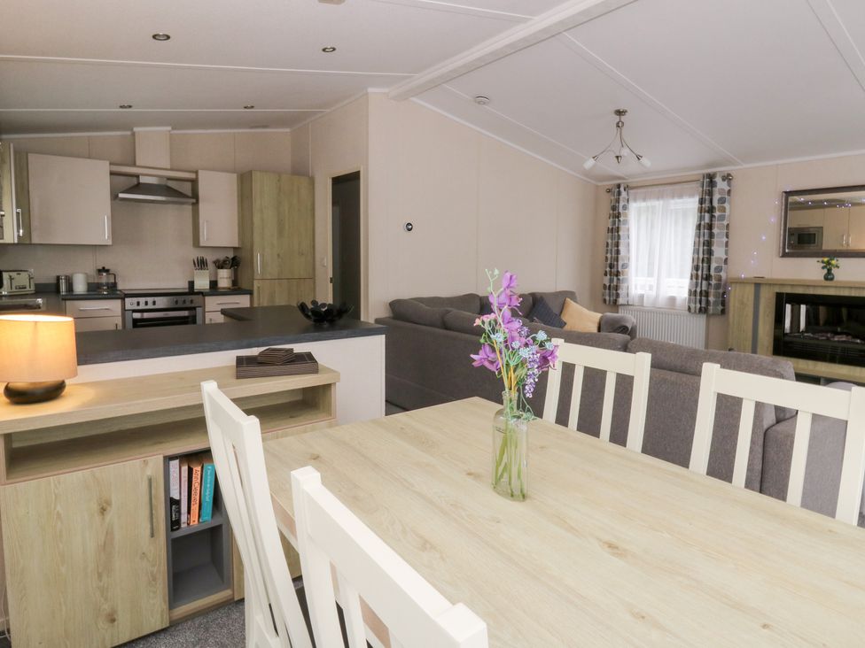 A living room with a dining table and sofa at Beechwood Lodge