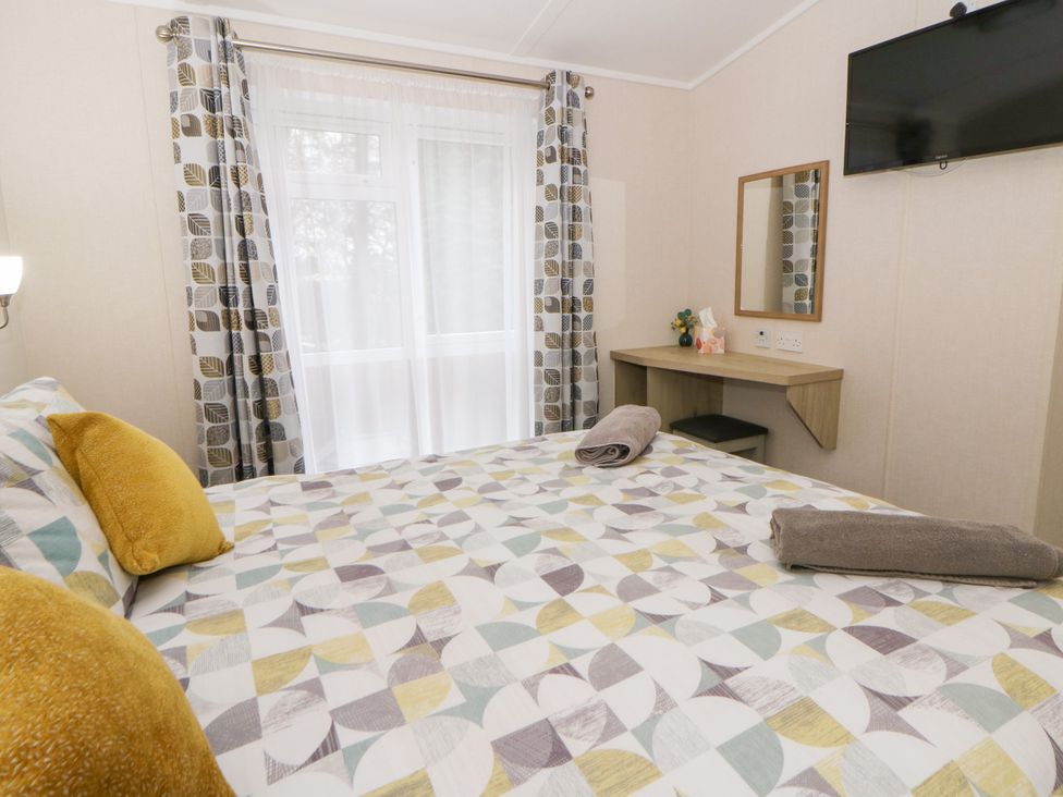 A bedroom with a bed and desk at Beechwood Lodge 
