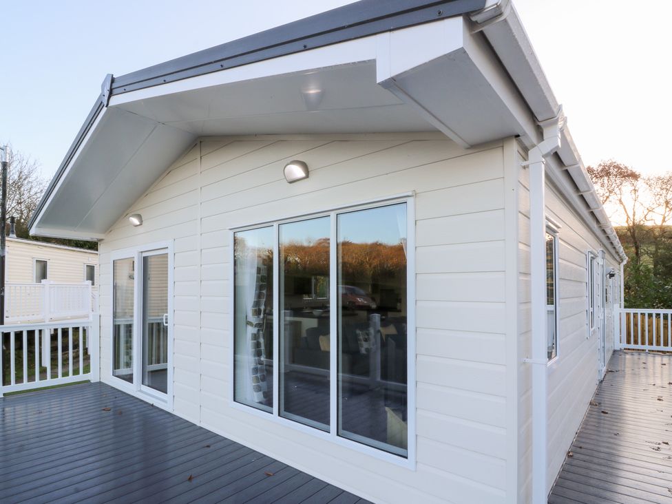 An exterior view of a house with windows and a deck at Beechwood Lodge