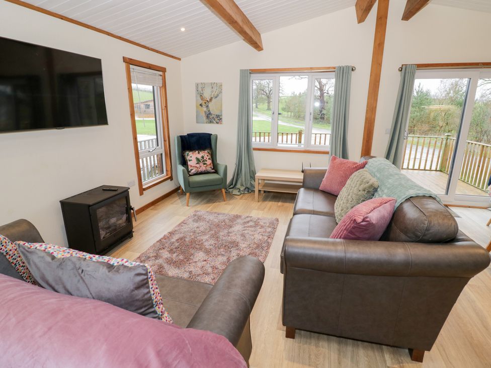 A living room with a sofa and armchair at Elm Lodge in Rugeley