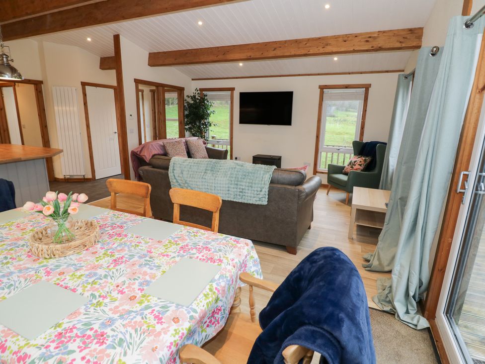 A living room with a sofa and dining table at Elm Lodge in Rugeley
