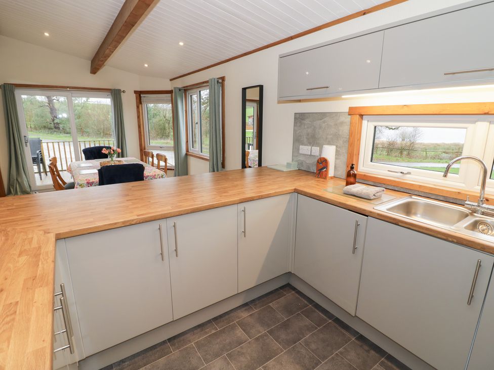 A kitchen with cabinets and a sink at Elm Lodge in Rugeley