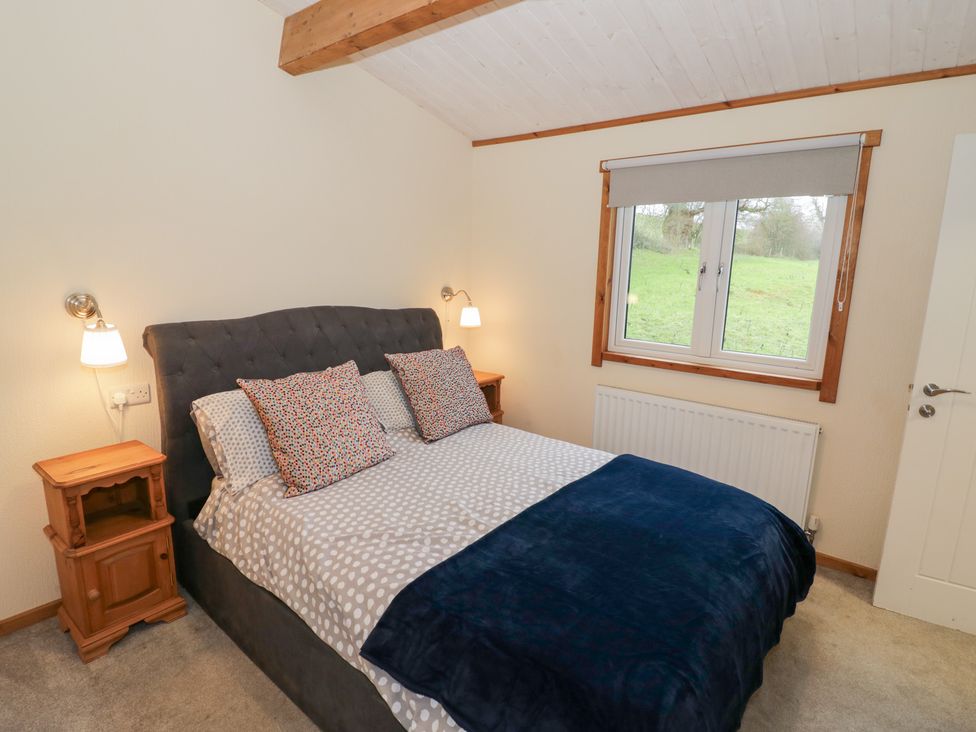 A bedroom with a bed and nightstand at Elm Lodge in Rugeley