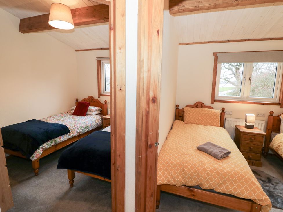 A bedroom with two beds and a window at Elm Lodge in Rugeley