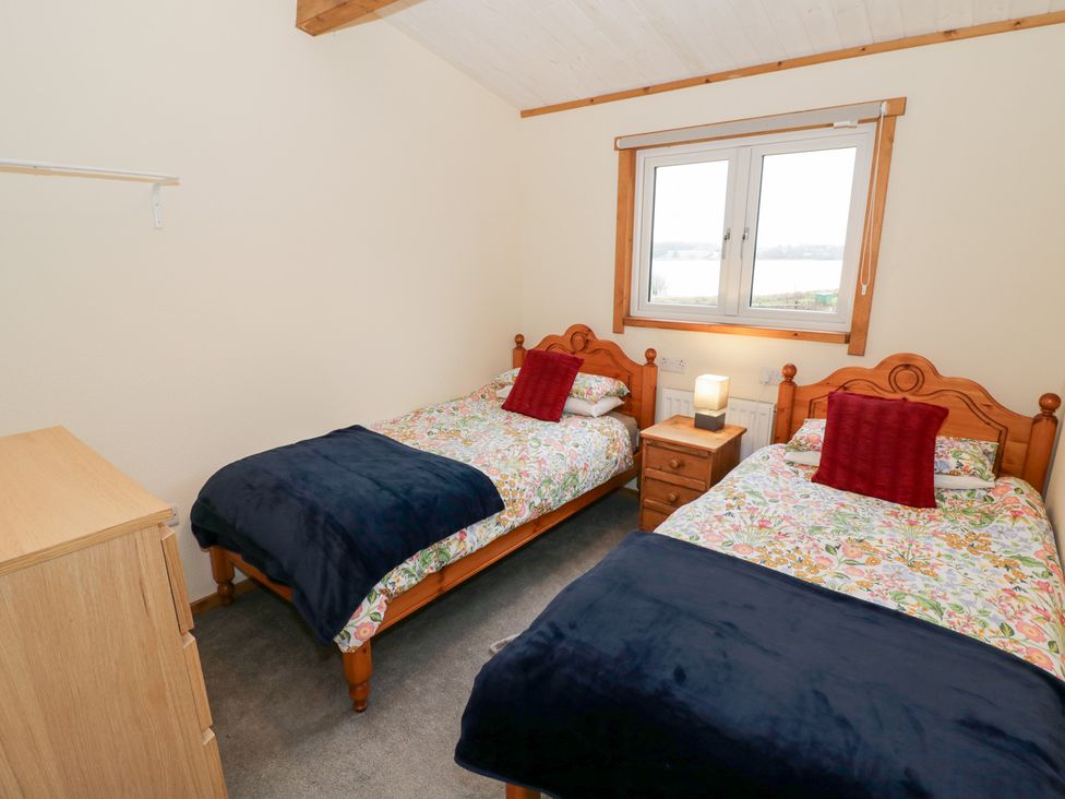 A bedroom with twin beds and a nightstand at Elm Lodge in Rugeley