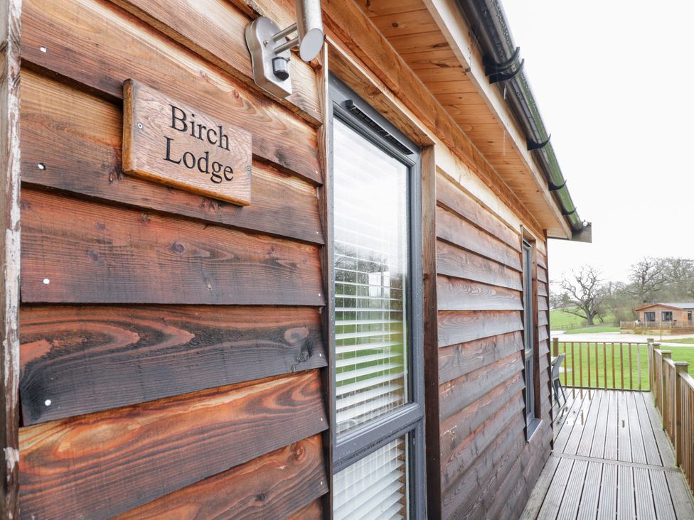 The exterior wooden wall with a sign for Birch Lodge in Rugeley