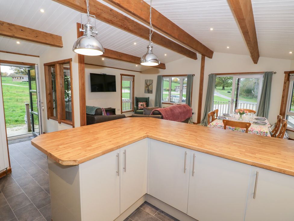 A kitchen with a dining area and living space at Birch Lodge in Rugeley