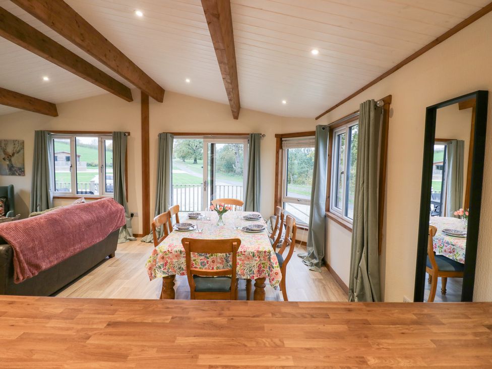 A dining room with a table and chairs at Birch Lodge in Rugeley
