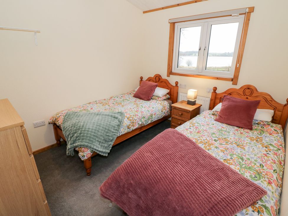 A bedroom with two single beds and a window at Birch Lodge Rugeley