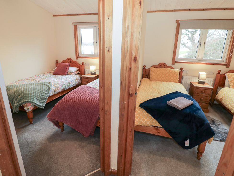 A bedroom with two single beds and a window at Birch Lodge in Rugeley