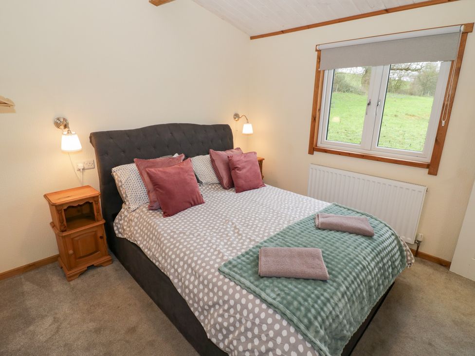 A bedroom with a bed and bedside table at Birch Lodge Rugeley